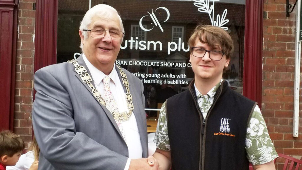 Image of chairman of North Yorkshire council with a big gold chain on shaking hands with Jack an autistic gentleman