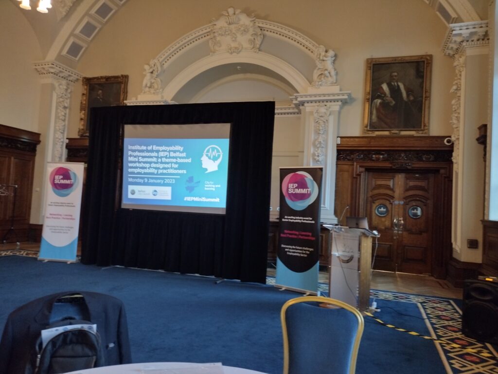 Image of large presentation screen with a speakers stand next to it