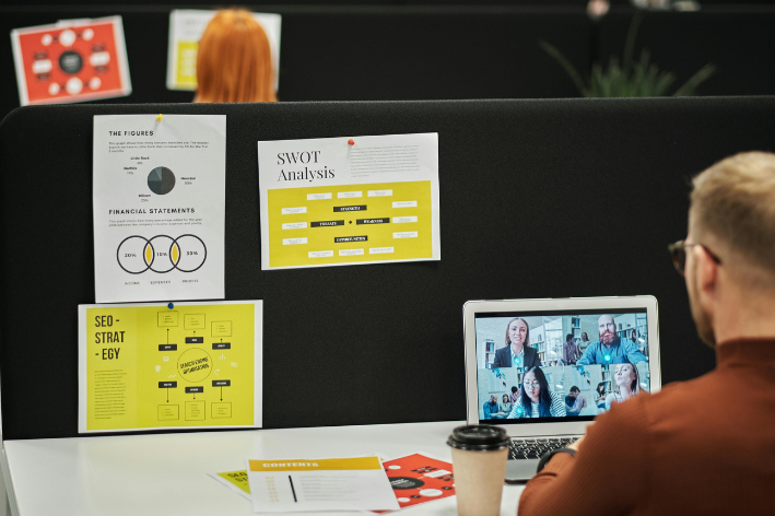 Person sat at desk taking part in a webinar on a laptop